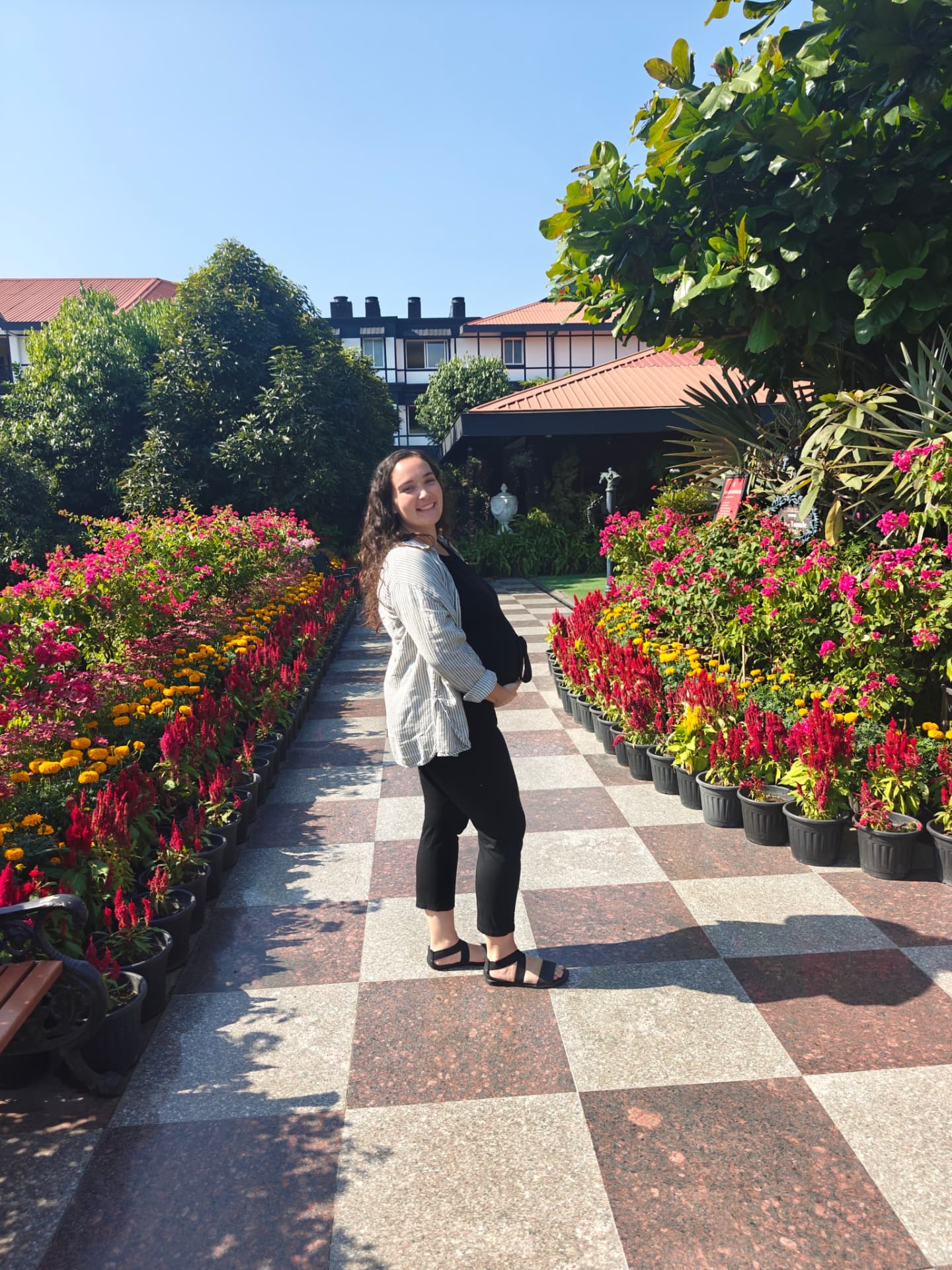 Megan during pregnancy on a path lined with flowers