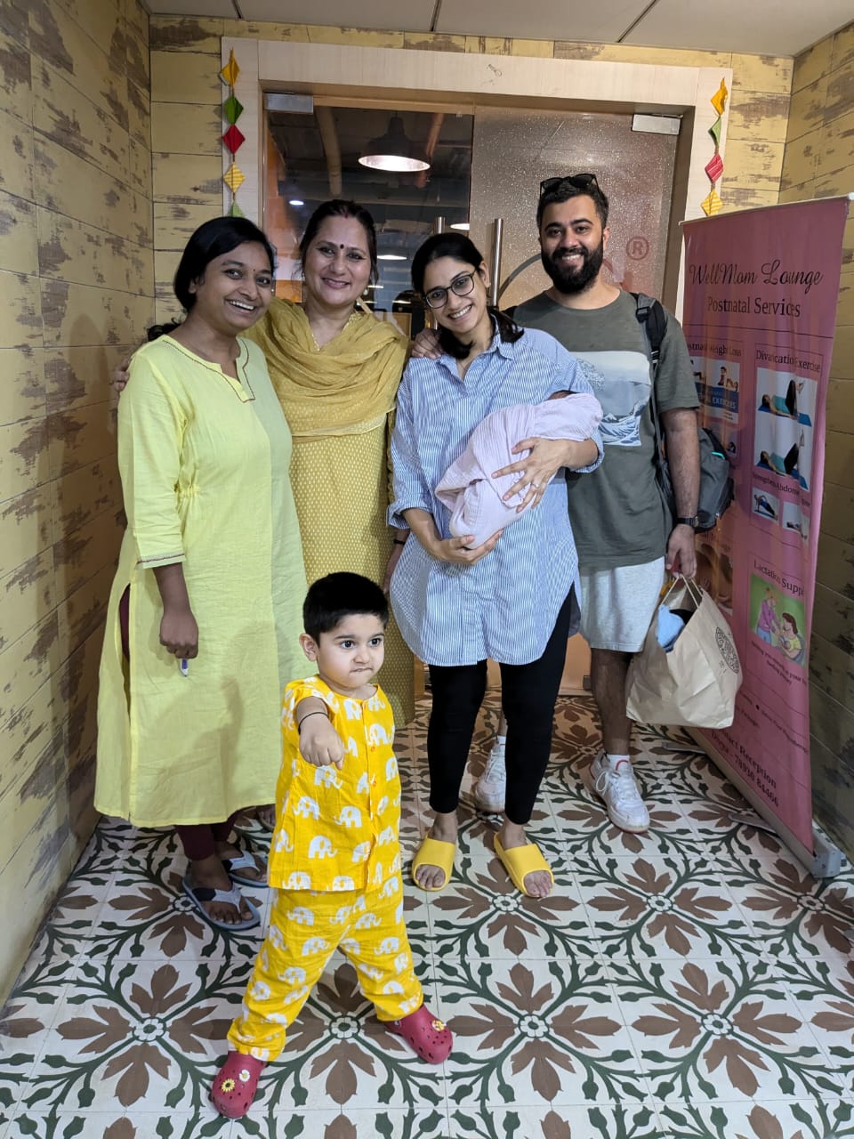 Meera with her family and care team as she leaves the birth centre with her newborn